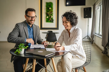 Mature woman sign insurance or contract to adult man in cafe