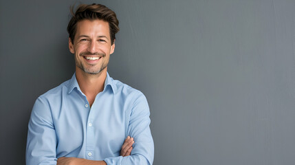 Wall Mural - Handsome smiling business man in blue shirt isolated on gray background