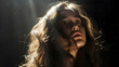 © Komkrit - Portrait of a woman with long hair, backlit to create a halo effect and deep shadows on her face.