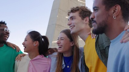 Wall Mural - Diverse young people having fun together embracing each other outdoor. Student teenage friends laughing while hanging out outside. Youth community concept.