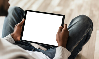 Blank screen, The tablet is positioned upright at eye level and has no background. It is positioned directly above their knee