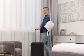 Sticker - Smiling guest with suitcase and backpack exploring stylish hotel room