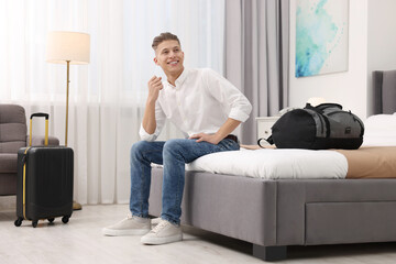 Sticker - Smiling guest relaxing on bed in stylish hotel room