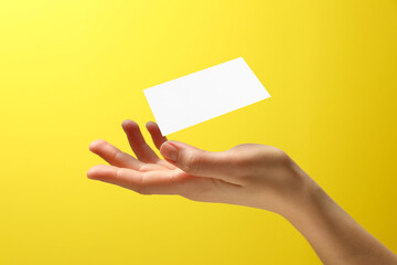 Sticker - Woman with blank business card on yellow background, closeup. Mockup for design