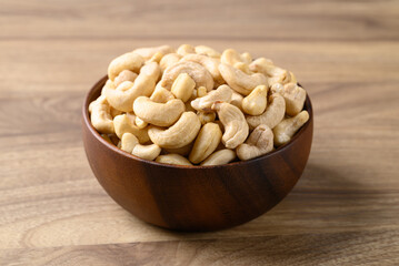 Wall Mural - Raw cashew nuts in bowl on wooden background, Food ingredient