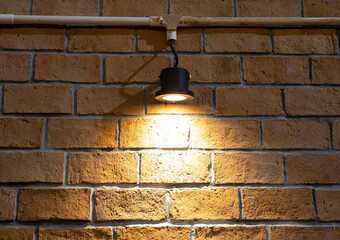 Wall Mural - The light of the lamp hits the brick wall. brown block