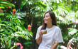 © Farknot Architect - Portrait image of a young woman holding and drinking coffee in the garden