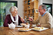 © peopleimages.com - Senior couple, tea and lunch in home for relax, food and drink for married man and woman. Living room, dinning room and table for retirement with romance, snacks and beverages for happy people