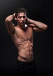 © peopleimages.com - Sexy, skin and man in studio for workout with fitness goals, sport training and progress results for muscle growth. Personal trainer, guy and torso abs for strong body and health by black background