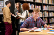 © peopleimages.com - Student, portrait and notebook in library for study, education and university quiz with pen on table. Man, book and knowledge on school campus for college exam, research and learning with scholarship