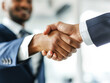 © Who is Danny - Close-up of a handshake between two people in business attire, blurred office background, concept of agreement. Generative AI