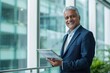 © Niks Ads - indian businessman holding tablet standing at office
