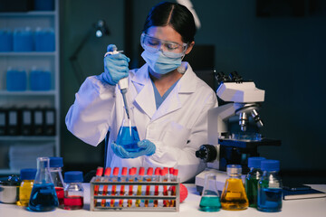 Medical or research scientist or doctor using looking at a test tube of clear solution in a lab or laboratory.