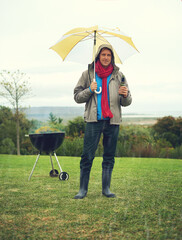 Wall Mural - Portrait, man and rain at barbecue in outdoor on vacation or picnic as family in together. Cheerful, male person and smile with umbrella, grill or bbq for celebration, birthday or event in Scotland