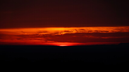 Poster - the setting sun rises in the horizon as seen from an airplane