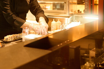 a person preparing food on a table at a restaurant bar