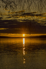 Wall Mural - Sunset over Lake Vasman in Ludvika County, Sweden and the colorful sky with clouds