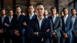 © Kanurism - Confident male businessman standing with his coworkers and looking at the camera