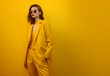 © K2Kstock - Female fashion model in yellow suit on yellow background