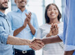© Katsiaryna - Successful Business Collaboration: Executives Greet with Handshake in Office