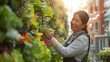 © mikhailberkut - A smiling woman cares for a lush vertical garden in an urban setting, highlighting urban gardening and sustainable living practices with the backdrop of city buildings