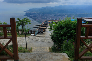 Wall Mural - Beautiful views from above, tables in a cafe in the mountains and a panoramic view of the city, public places in Turkey, on a sunny summer day