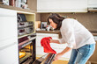 © Halfpoint - Mature woman preparing homemade lasagna, holding hot glass baking dish.