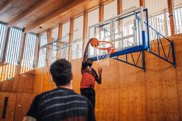 Wall Mural - Portrait of an african basketball player dunking the ball into hoop