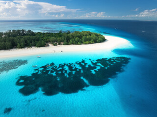 Wall Mural - Aerial view of blue sea and amazing Mnemba island, Zanzibar. Top drone view of white sandy beach, boats, green palms, ocean with clear azure water in summer. Tropical background. Seascape. Travel