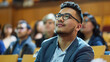 © Lull - Attentive student in lecture hall. A young man listens intently to a lecture, surrounded by other students in a university lecture hall.