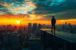 © mankjon - A silhouette of a man standing on the edge of a skyscraper rooftop, overlooking a vibrant cityscape at sunset with dramatic clouds and glowing skyline