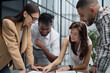 © Katsiaryna - Group of young business people working together while standing in creative office