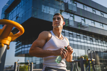 Canvas Print - man young male athlete hold bottle of water drink training outdoor