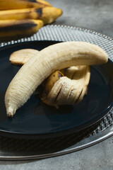 Sticker - A view of a peeled banana on a plate.