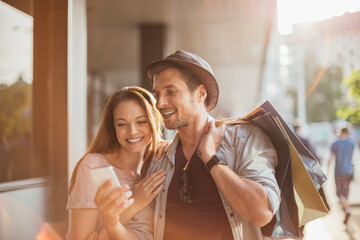 Wall Mural - Happy couple shopping together in the city