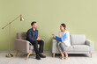 © Pixel-Shot - Human resources manager interviewing applicant near green wall in office