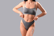 © Pixel-Shot - Beautiful young woman in grey underwear on light background