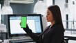 © DC Studio - Developer shows mobile phone with greenscreen template, working in small business coworking space. Engineer using isolated copyspace layout on blank mockup screen, chromakey background.