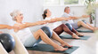 © JackF - Group of elderly people doing pilates exercises with soft ball on mat in fitness studio