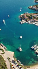 Wall Mural - Aerial view of the picturesque village and port of Fiskardo on the island of Kefalonia, Greece. Sailboats and yachts are docked in the charming fishing village of Fiskardo.