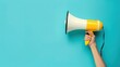 © Nany - hand hold a megaphone is isolated copy space on blue background with minimalist style