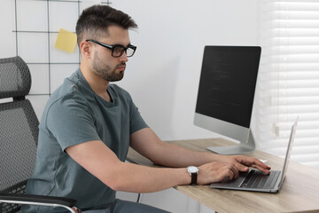 Young programmer working at desk in office