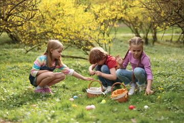 Poster - Easter celebration. Cute little children hunting eggs outdoors