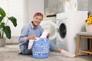 Canvas Print - Happy housewife with laundry basket near washing machine at home