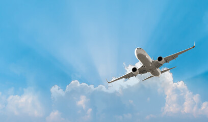 white passenger airplane flying in the sky amazing clouds in the background - travel by air transpor