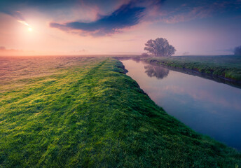 Wall Mural - Grassland on the shore of Strypa river. Fantastic summer sunrise in Ukrainian countryside. Foggy morning scene of Ternopil outskirts, Ukraine, Europe. Beauty of countryside concept background..