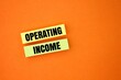 © Fauzi - colored paper with the word Operating income.company's profit after deducting operating expenses which are the costs of running the day-to-day operations