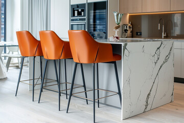 Canvas Print - Stylish orange leather bar stools in a minimalist kitchen with a marble island and sleek appliances, creating a bold and modern look