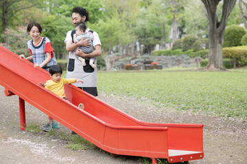 Poster - 保育園の園庭や滑り台で子どもたちを見る先生　広角