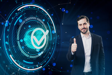 Attractive young european businessman showing thumbs up to glowing digital checkmark hologram on dark blue polygonal background. The best quality assurance service concept.